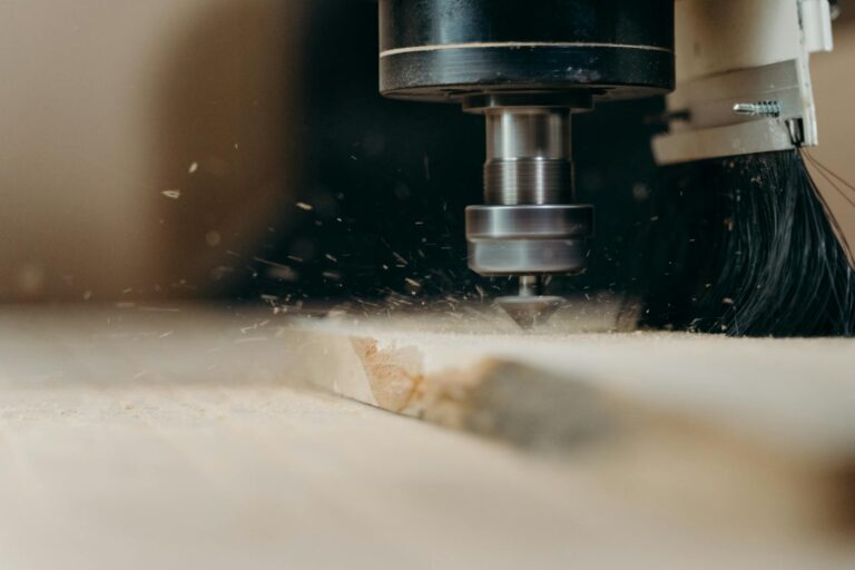 Was ist CNC-Technik? CNC machine in action, precisely cutting a wooden panel with sawdust flying.