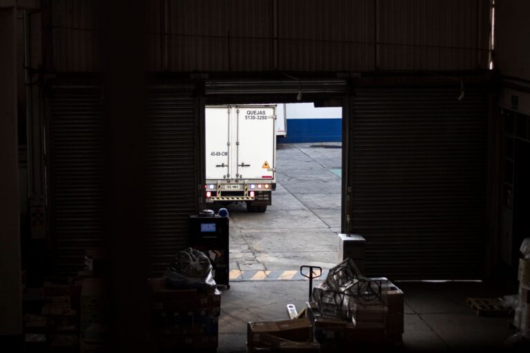 Frachtkosten bei Maschinenbeschaffung richtig kalkulieren und einplanen Transportkosten – verpackte Industriemaschine auf einem Tieflader